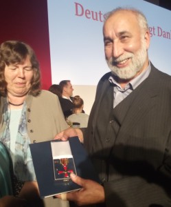 DAF-Gründer Aga Zia Farsin hält das Bundesverdientskreuz in den Händen.